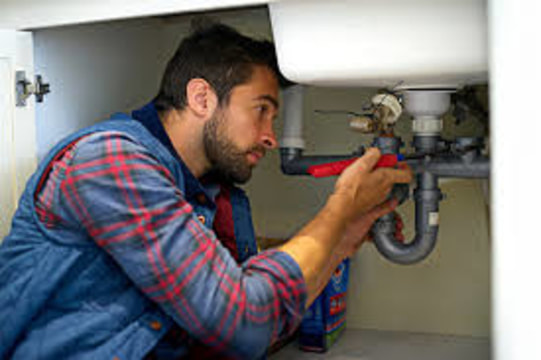 plumber working on sink 